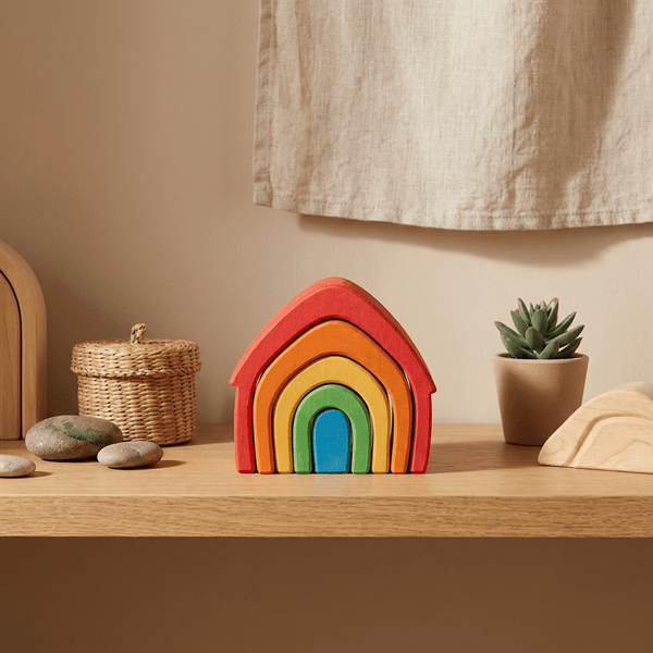 Montessori rainbow house wooden stacker in red, orange, green and blue arches on a styled shelf