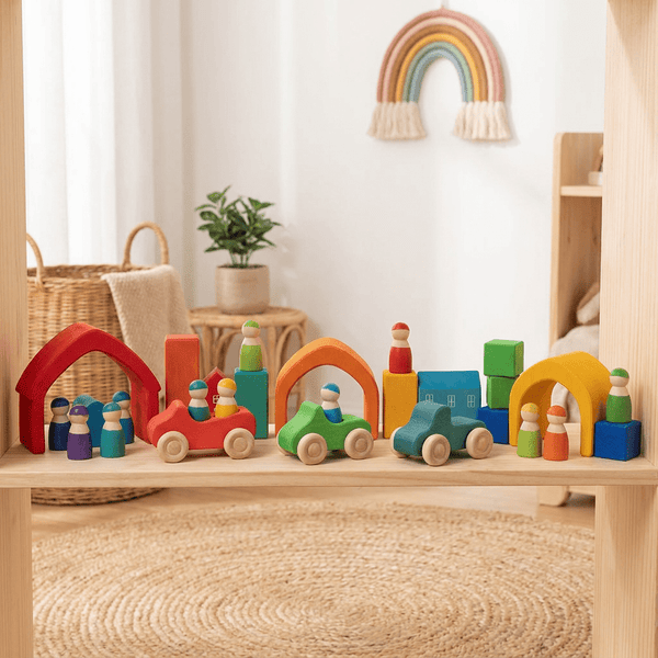 Colourful wooden Montessori toy collection with rainbow house stacker, cars and peg dolls on a shelf